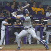 a baseball player getting ready to swing at a pitch with a lsu banner in the background