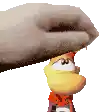 a hand is holding a toy that looks like a rayman character .