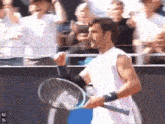 a man holding a tennis racquet in front of a crowd with the number 40 on the bottom