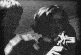 a black and white photo of a man smoking a cigarette and a woman holding a gun .