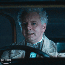 a man in a suit and bow tie is sitting in a car with the word prime on the bottom right