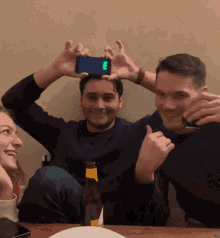 a man holds up a phone with the letter e on the screen