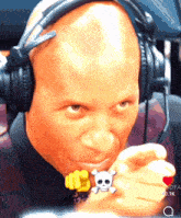 a man wearing headphones has a skull and crossbones ring on his finger