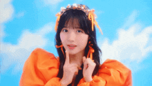 a girl wearing an orange dress and a headband with orange ribbons