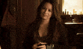 a woman with long hair is holding a cell phone