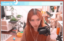 a woman with red hair is sitting in front of a microphone in a room .