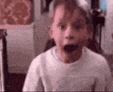 a close up of a young boy with his mouth open .