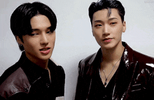 two young men are standing next to each other looking at the camera