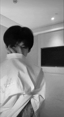 a black and white photo of a young man wearing a white shirt that says wsy kol