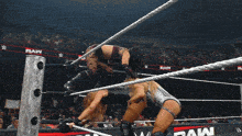 two women are in a wrestling ring with the word raw on the ropes