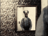 a black and white photo of a man with suspenders is framed on a wall