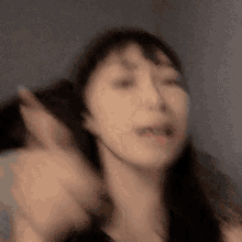 a blurry picture of a woman 's face with her hands in the air .