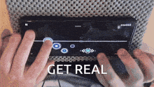 a person playing a game on a cell phone with the words get real written below them