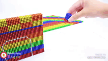 a person is playing with a rainbow colored toy that is made by animatica