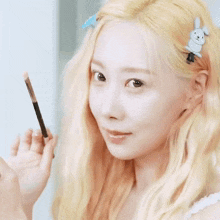 a woman with blonde hair has a bunny hair clip