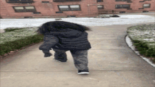 a person with long hair is walking down a sidewalk