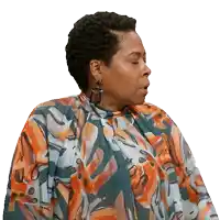 a woman wearing a floral dress and earrings looks to her left