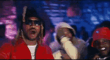 a man wearing a mask and a red jacket is dancing in a club .