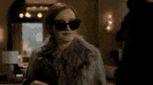 a woman in a fur coat is talking on a cell phone