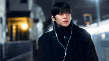a young man wearing ear buds is looking at the camera