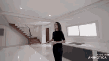 a woman stands in a kitchen with the words made in animatica on the bottom right