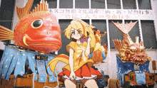 a girl in a red dress is standing in front of a large fish statue