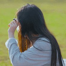 a woman covering her face with her hair while wearing a mask
