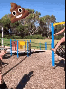 a poop with a smiling face is flying in the air at a playground