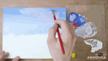 a person is painting a blue sky with a brush on a canvas