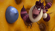 a cartoon of two bees looking at a blue object