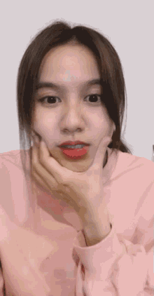 a woman in a pink sweater is making a funny face