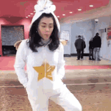 a woman in a white onesie with a star on the front