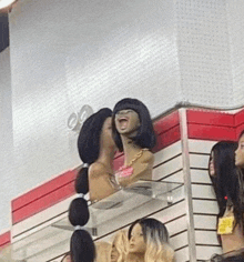 a woman 's head with a wig on it is sitting on a glass shelf in a store .