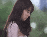 a woman with long dark hair is looking down