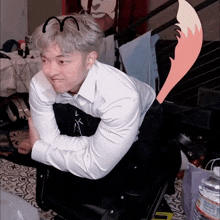a man wearing a white shirt and black pants is kneeling down