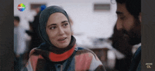 a woman in a hijab talks to a man in a show called show