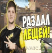 a man in a black and yellow shirt is pointing at something while holding a gun and a piece of paper .