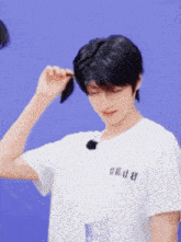 a young man wearing a white shirt with chinese writing on the front