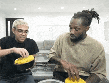 two men are sitting at a table eating food