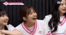 a group of girls are sitting next to each other laughing and smiling .