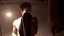 a shirtless man is holding a towel over his face .