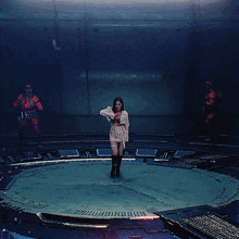 a woman is standing in a circle with her arms outstretched in front of a man in a gas mask