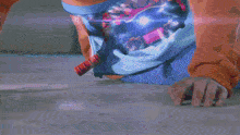 a person in a blue shirt is holding a purple object in their hand