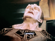 a close up of a person 's face with the word groaning on the bottom right