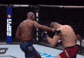 two men are fighting in a ring with a sign that says vegas stronger on it