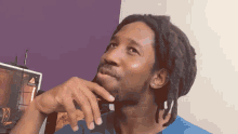 a man with dreadlocks is looking up at something with a warning sign in the background