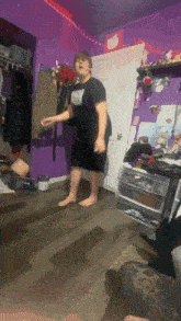 a person in a room with a purple wall and a hello kitty on the door