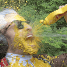 a man is covered in mustard while holding a bottle