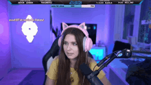 a girl wearing pink headphones is sitting in front of a microphone and a screen that says jenny lindy on it