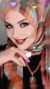 a woman wearing a scarf and a necklace is smiling and wearing a ring